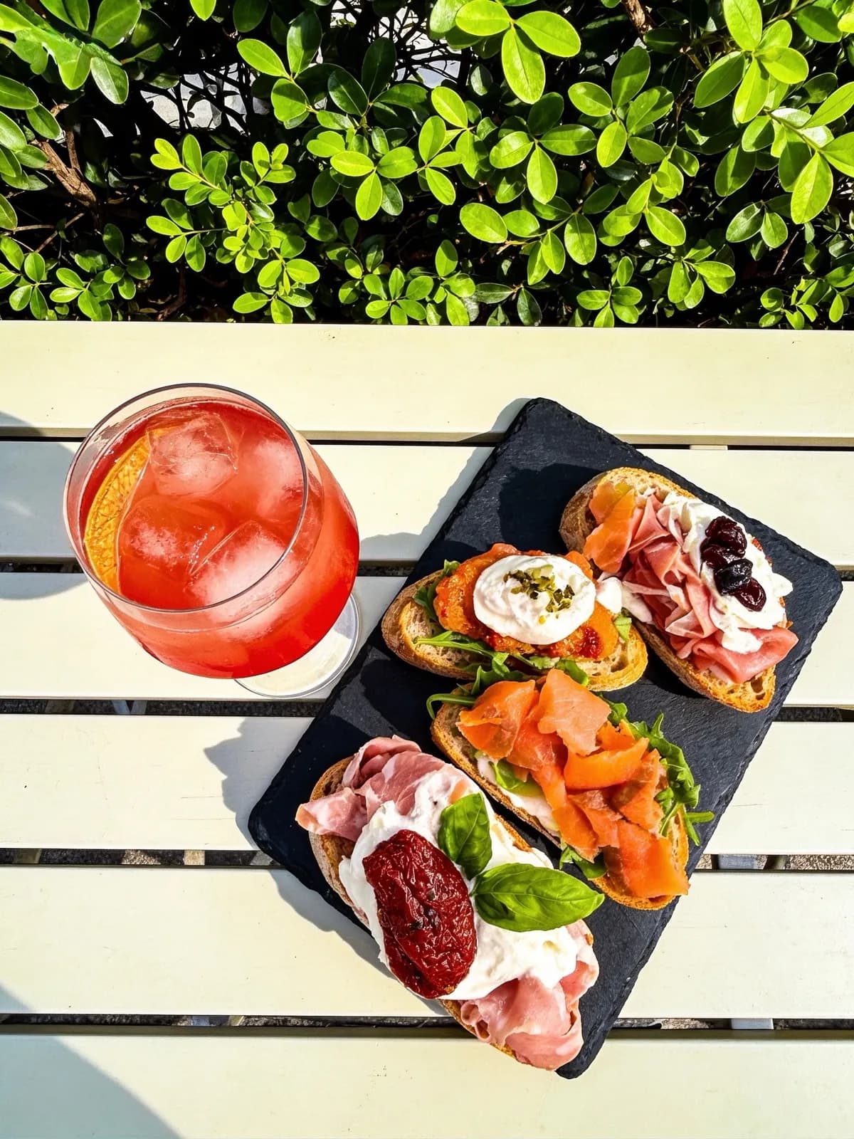 Uno spritz e quattro crostini su un tagliere d’ardesia